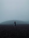Anonymous woman walking in highlands on misty day