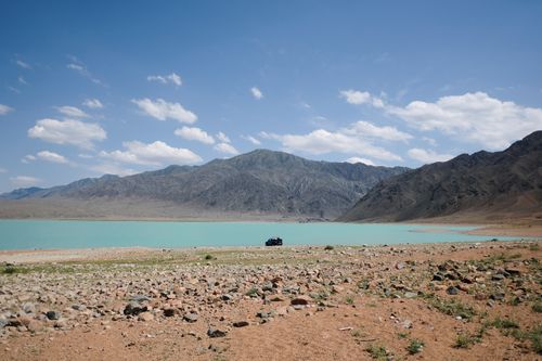 Free Breathtaking view of a serene lake surrounded by mountains in Kazakhstan under a clear blue sky. Stock Photo