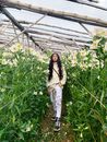 一位年轻人在鲜花盛开的温室里散步，享受着宁静，四周环绕着生机勃勃的植物
