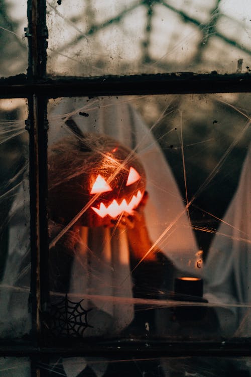 Carved Pumpkin with a Candle Inside and Halloween Decorations 