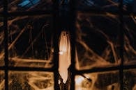 昏暗的房间里站着一个幽灵般的身影，营造出诡异的万圣节氛围