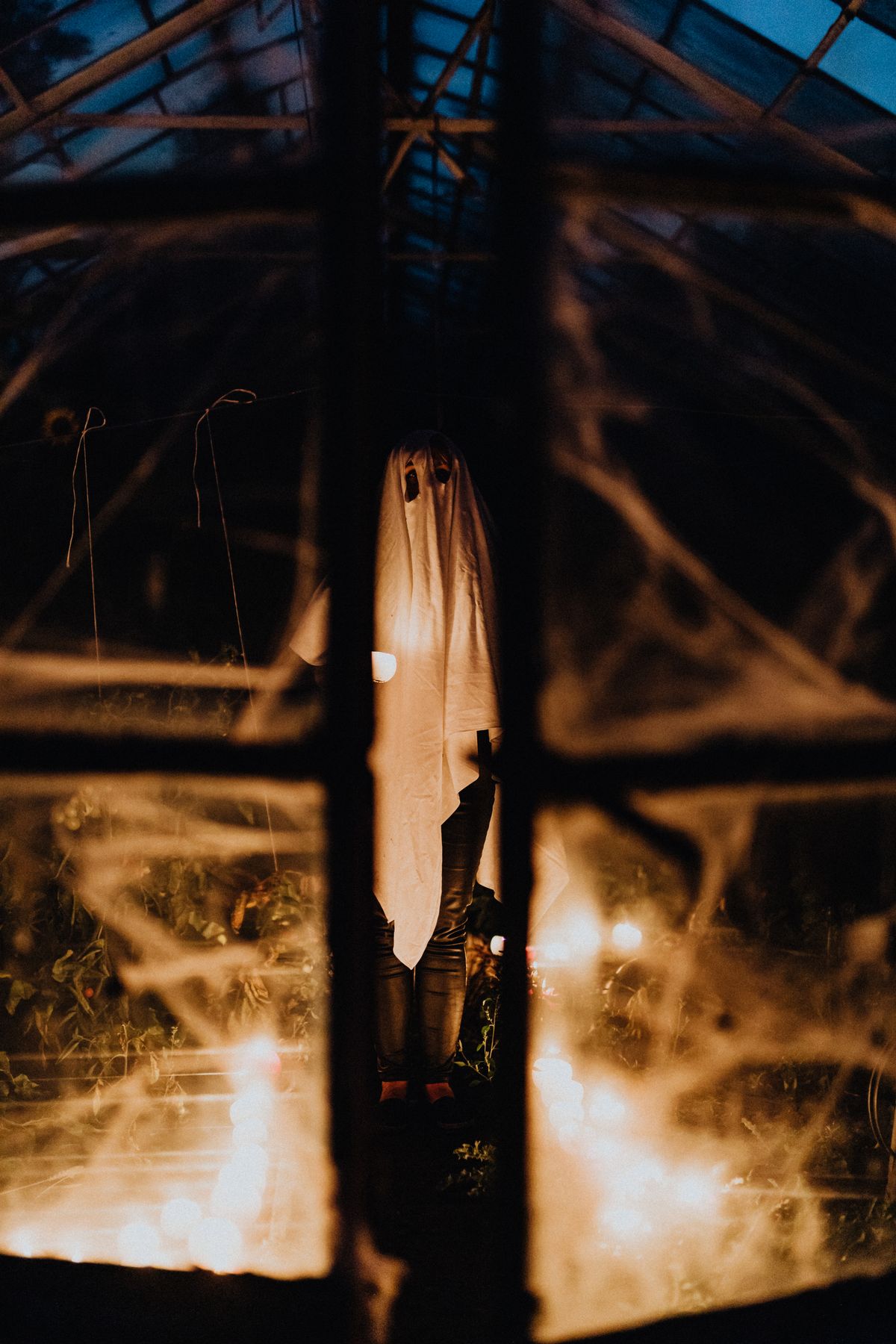 Ghostly figure behind a glass door with cobwebs for a goosebumps Halloween porch