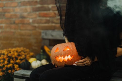 Free A mysterious Halloween scene featuring a glowing Jack-O'-Lantern and autumn decor. Stock Photo
