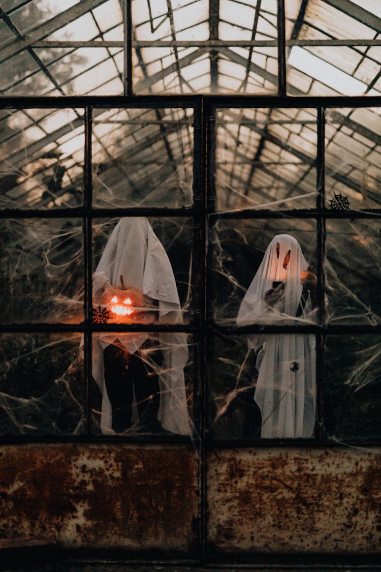 People Wearing Halloween Costumes In A Greenhouse