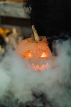 Eerie close-up of a glowing jack-o'-lantern surrounded by mysterious smoke, perfect for Halloween.
