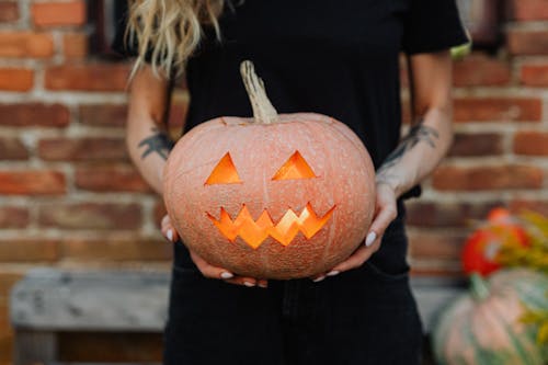 A Person Holding a Carved Pumpkin