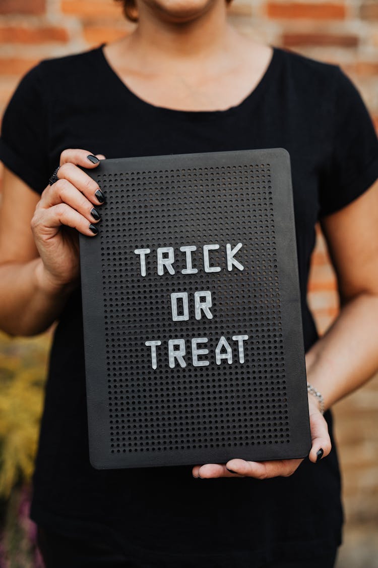 Person Holding A Trick Or Treat Sign