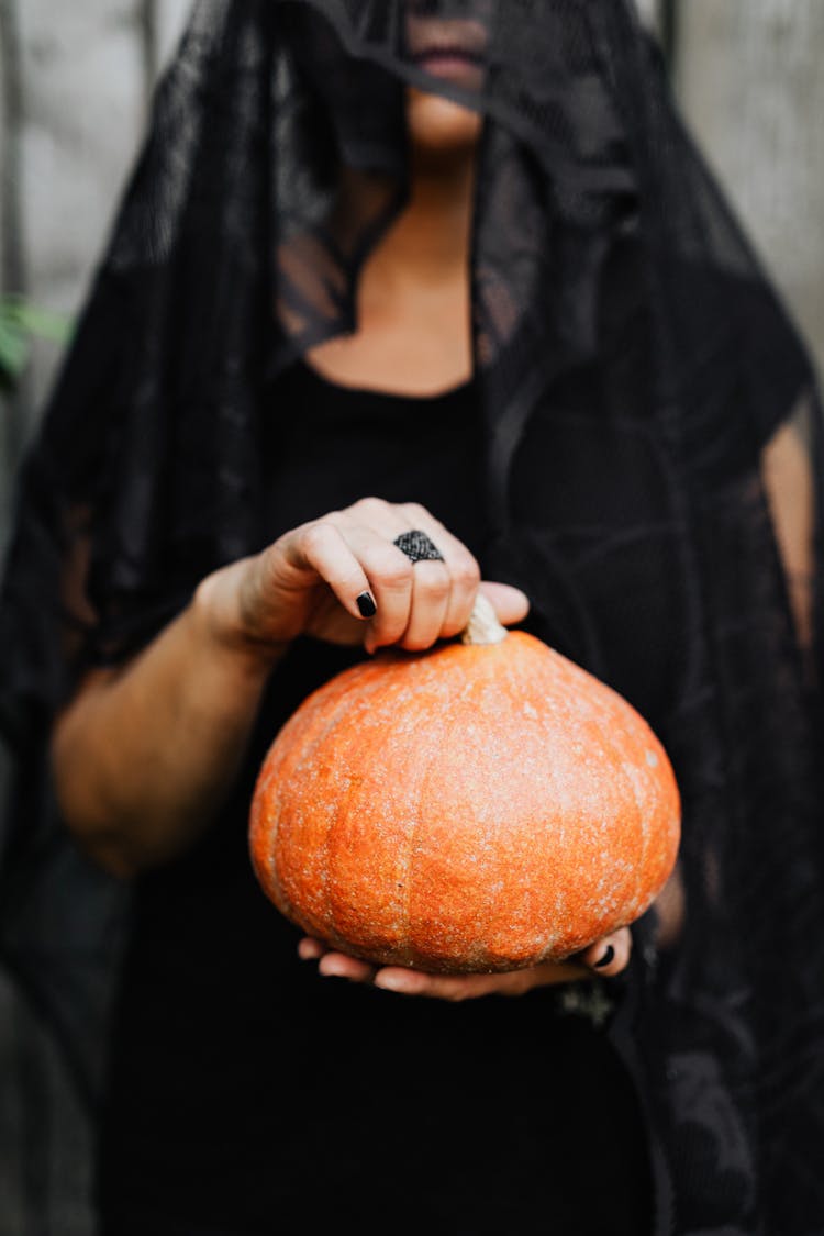 Woman In Black Veil Holding Pumpkin