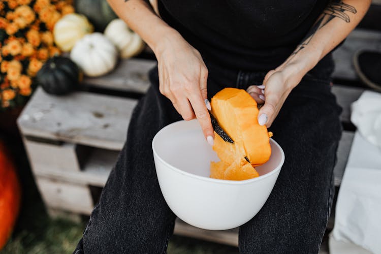 Unrecognizable Woman Slicing Small Pumpkin