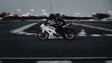 Man in Black and White Motorcycle Suit Riding on Motorcycle