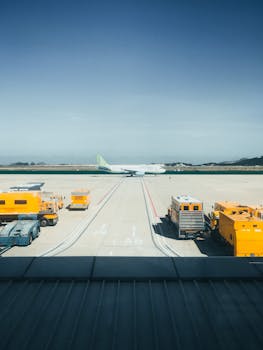 Aviation scene with airplane and ground support vehicles at Cam Ranh airport runway in Vietnam.
