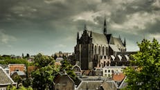 在荷兰莱顿，一座哥特式教堂矗立在多云的天空下，被城市景观所环绕