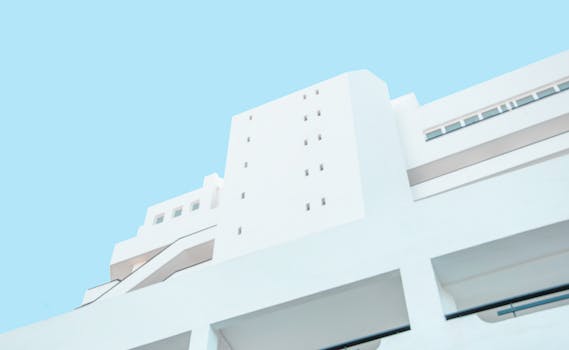 低角度视角下，现代白色建筑立面与清澈的蓝天相互映衬