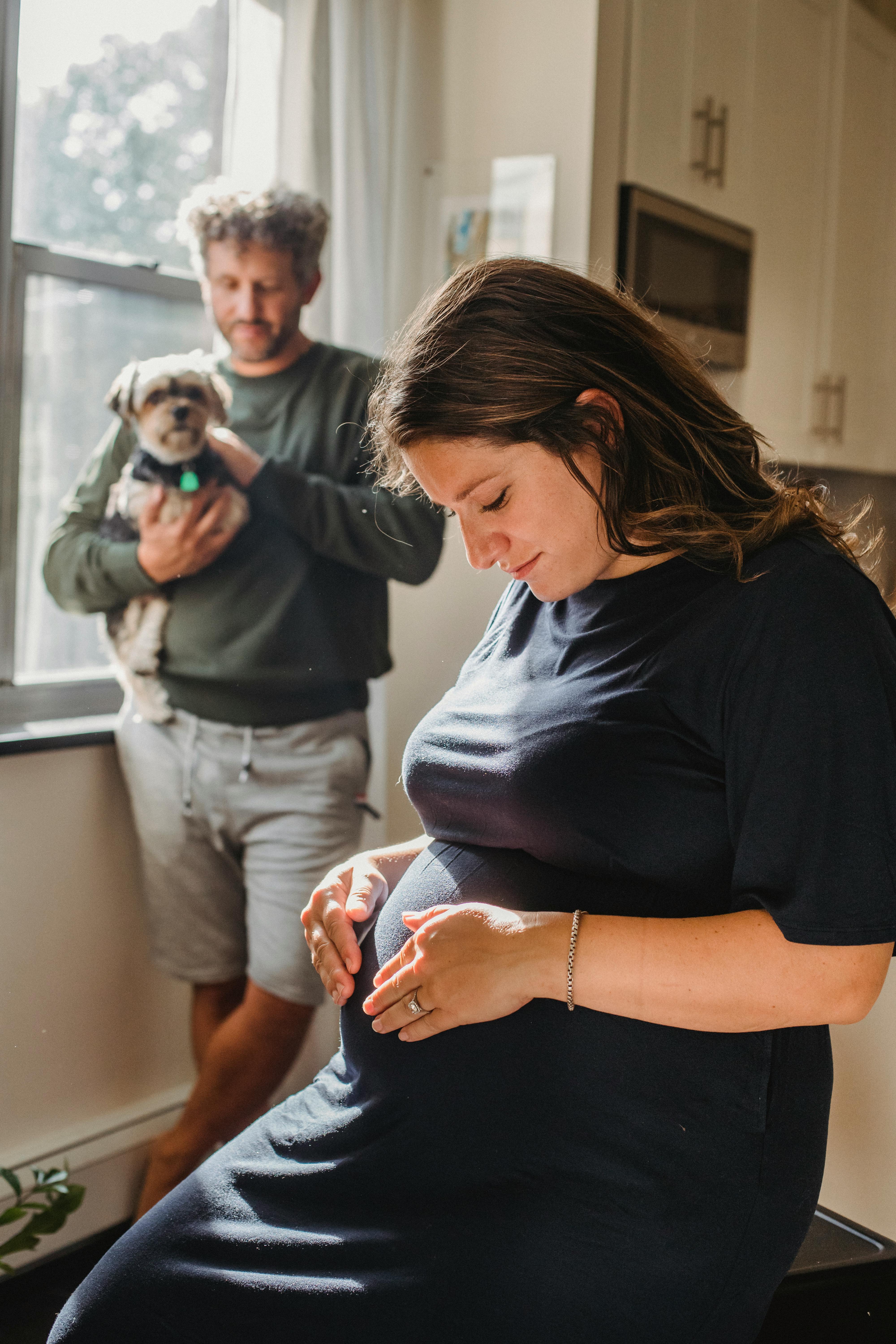 Pregnant female against calm man with dog · Free Stock Photo