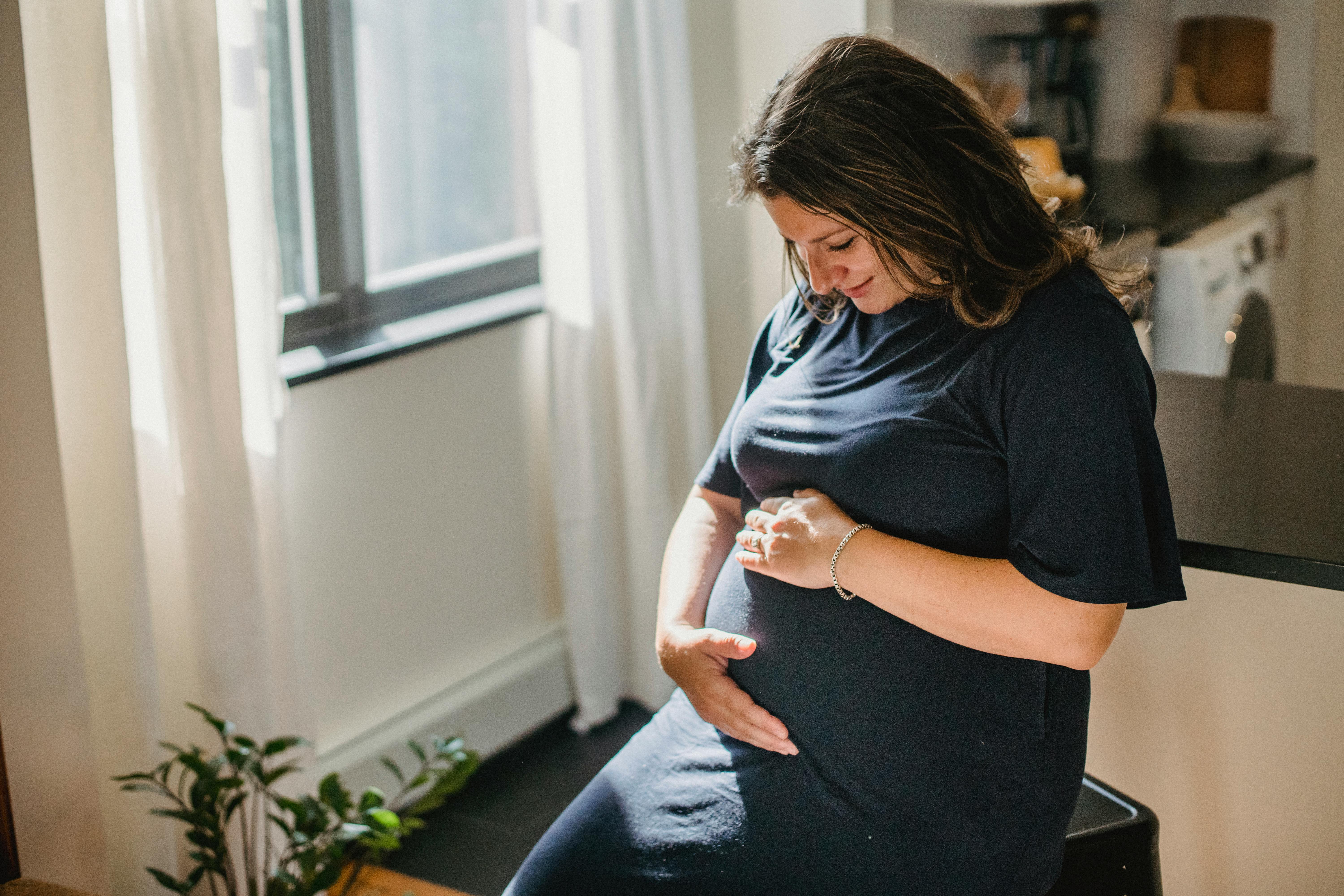 cheerful pregnant woman touching belly