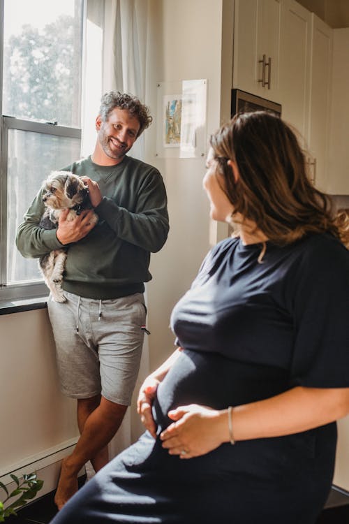 Happy couple with dog looking at each other