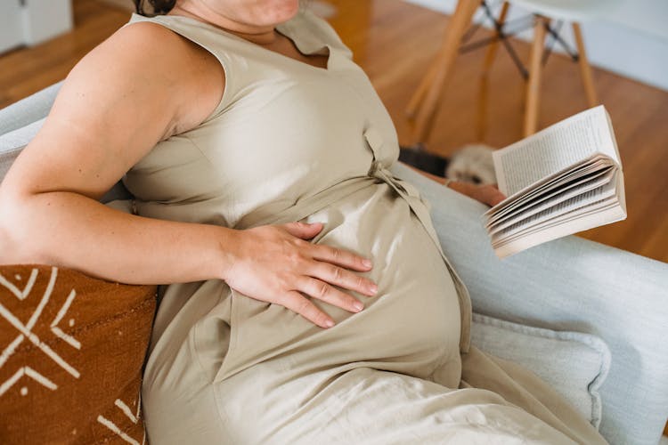 Crop Pregnant Woman Reading Book