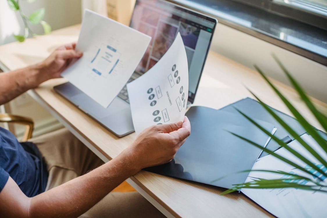 A Person Looking at Company Papers, Representing the Important Work of SOP Writers in Clarifying a Company's Standard Operating Procedure