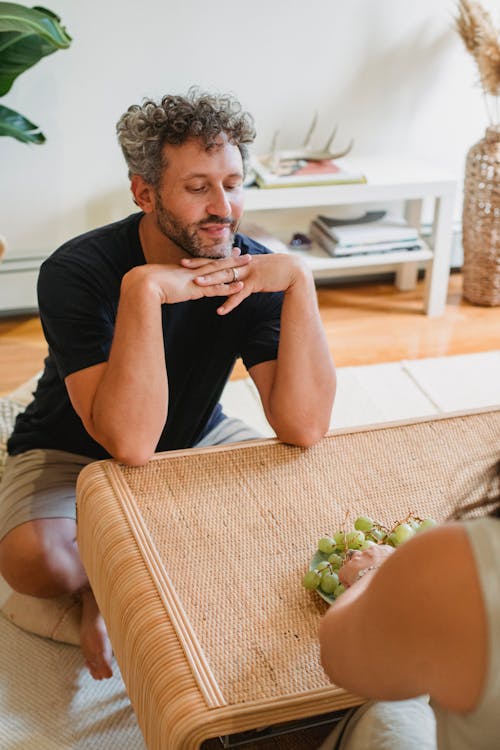 Cheerful bearded man with wife in living room