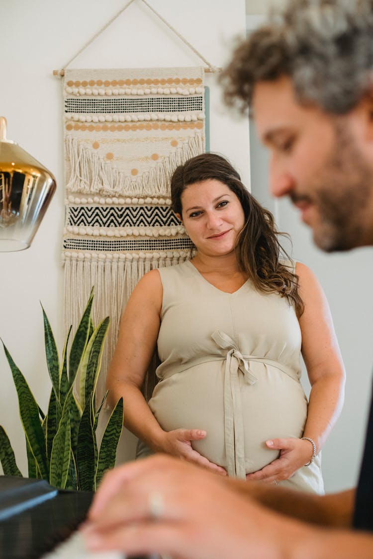 Happy Pregnant Woman Listening To Husband Playing Piano