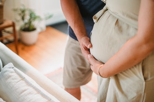 Erntepaar, Das Schwangeren Bauch Mit Händen Zu Hause Berührt