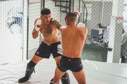 MMA sparring between two athletes in a gym setting, showcasing skill and intensity.