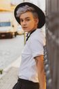 Woman in White Button Up Shirt Wearing Black Hat Standing on Sidewalk