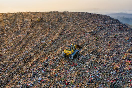 Drone shot capturing environmental impact at a landfill in West Java with visible machinery.