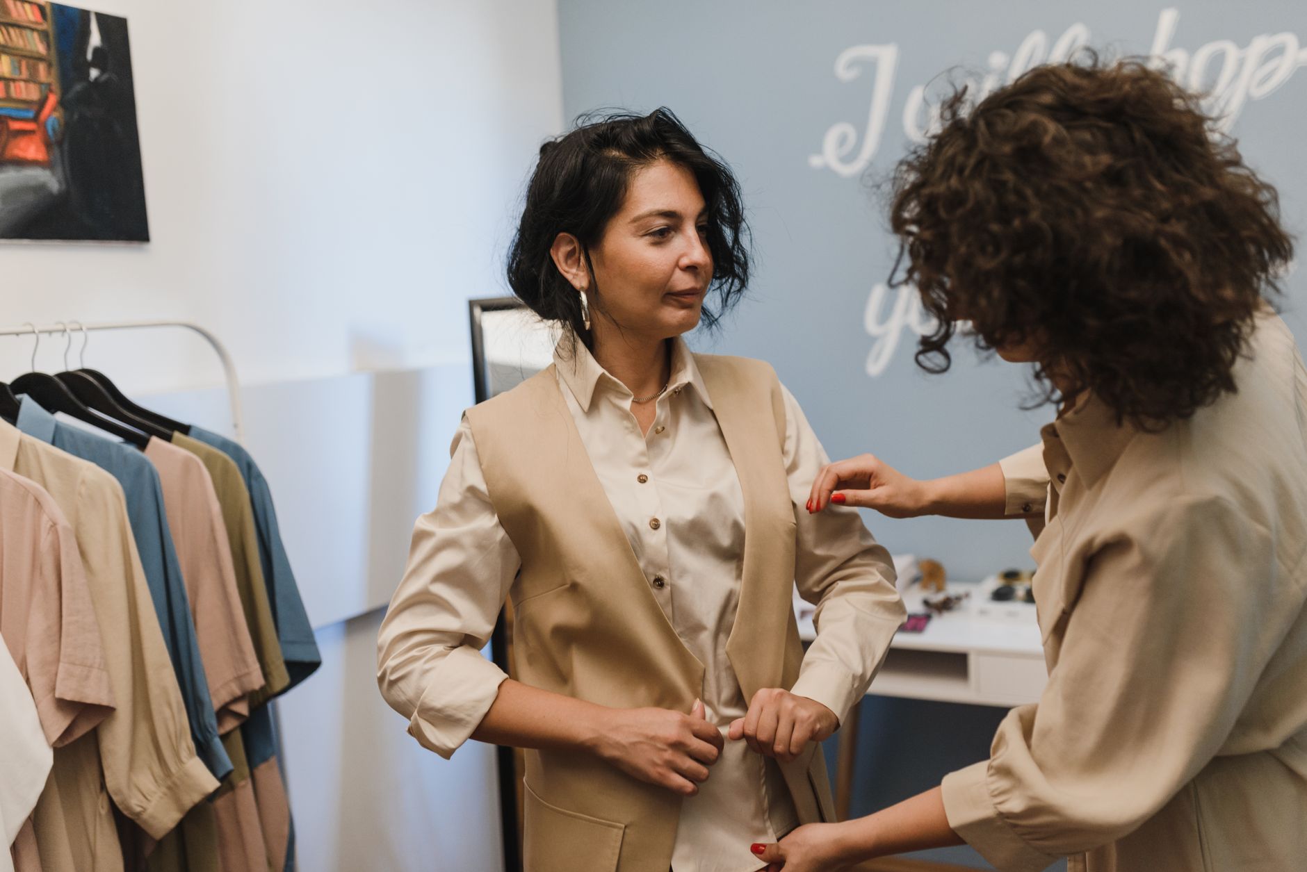 A woman stands before a closet of professional clothing, assessing which pieces signal readiness for promotion