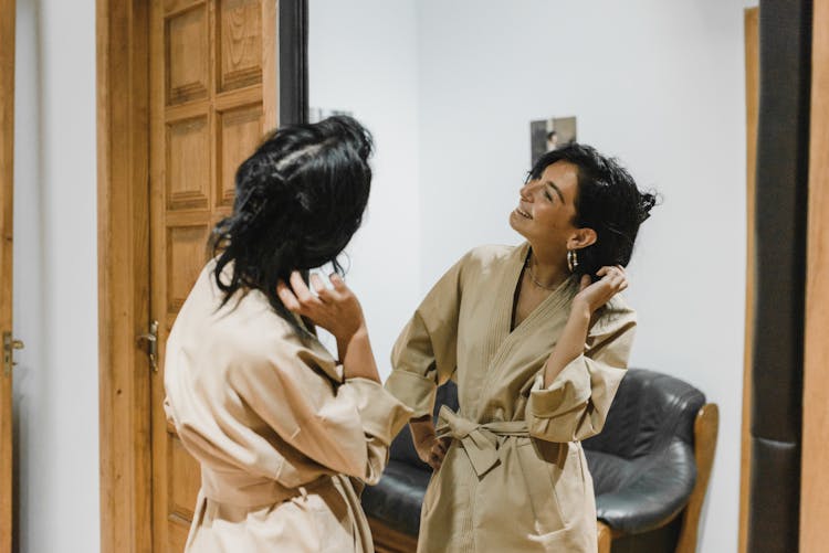 Woman In Brown Robe Standing In Front Of Mirror