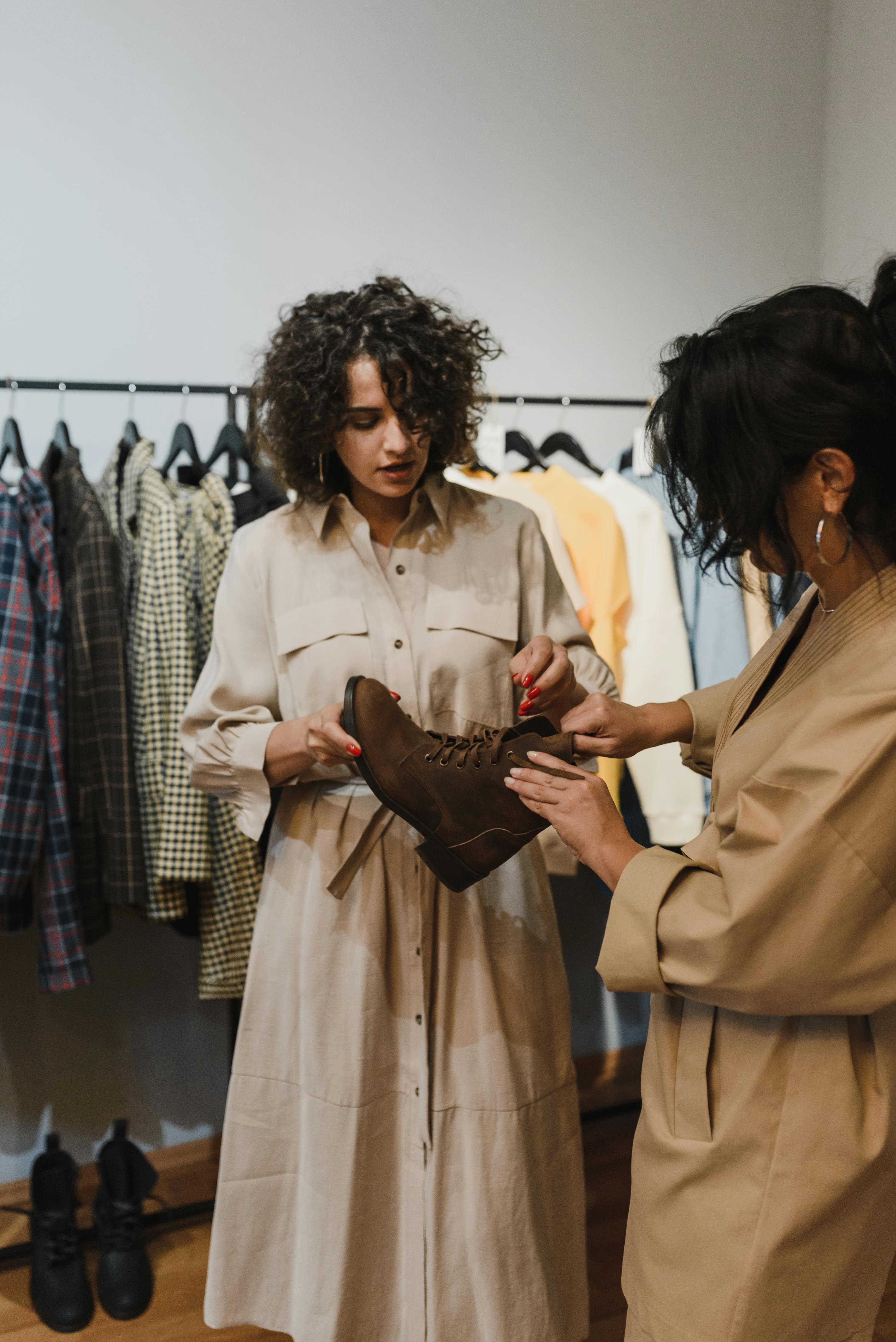 两名妇女在一家时尚服装精品店购买棕色靴子