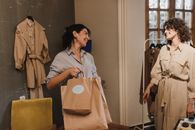两名妇女在一家精品店微笑着提包购物