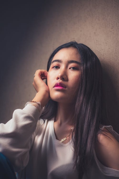 A Beautiful Woman Posing while Leaning on a Wall