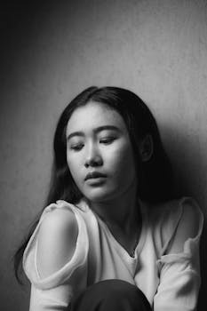 一位闭着双眼的年轻女子的黑白肖像，透出沉思的意境