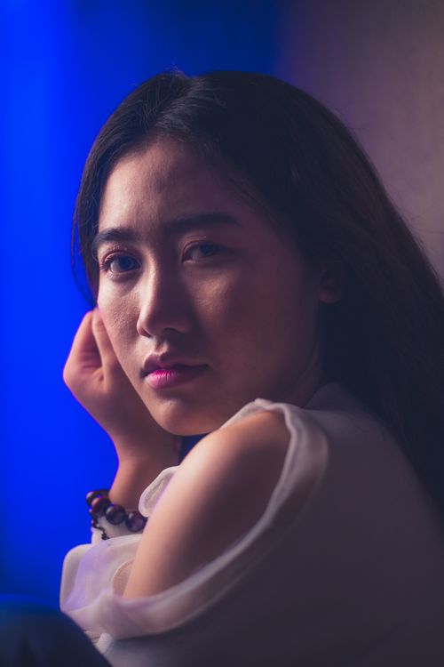 Free A captivating portrait of a woman in thoughtful reflection, captured in a moody setting. Stock Photo