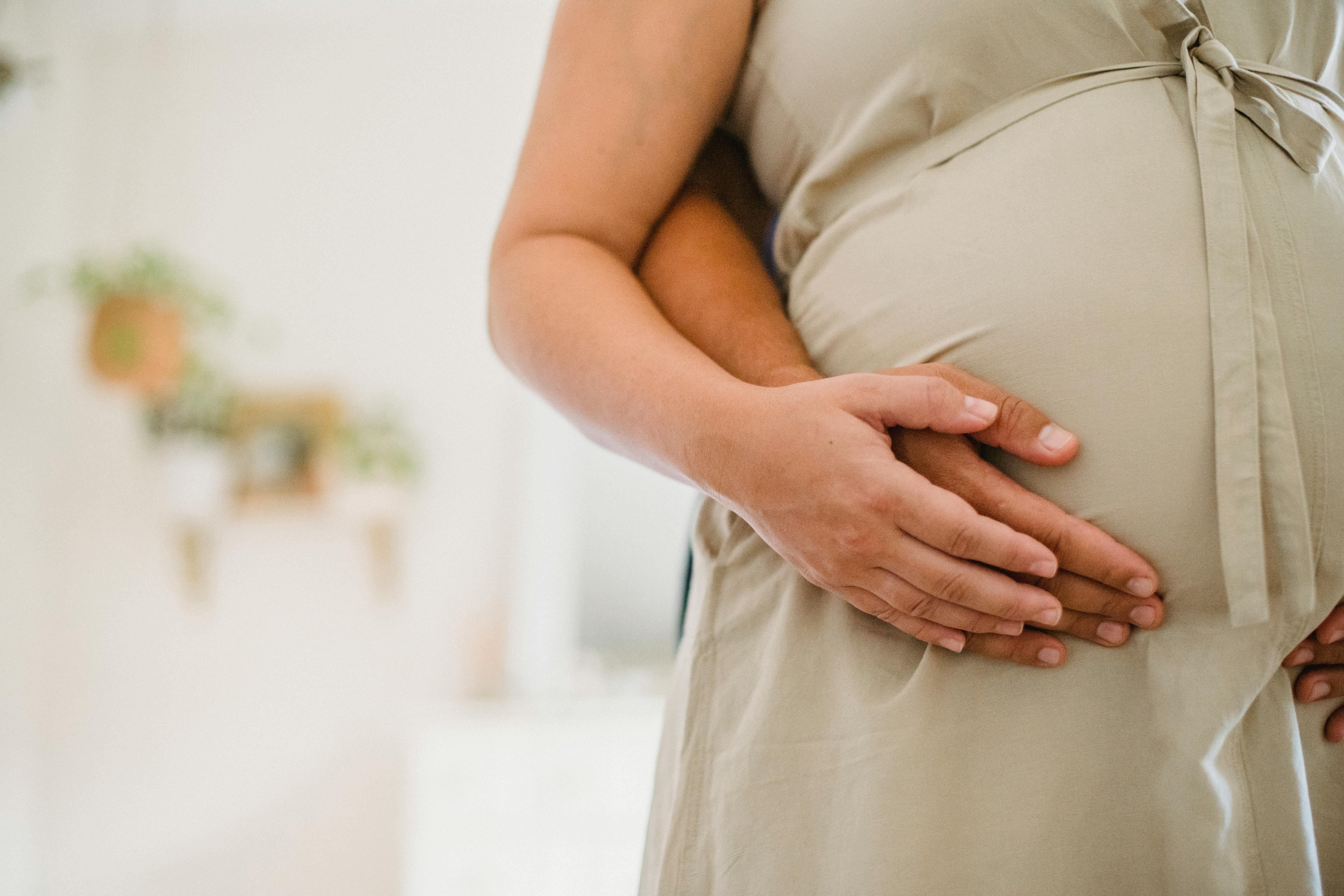 anonymous man touching pregnant woman belly