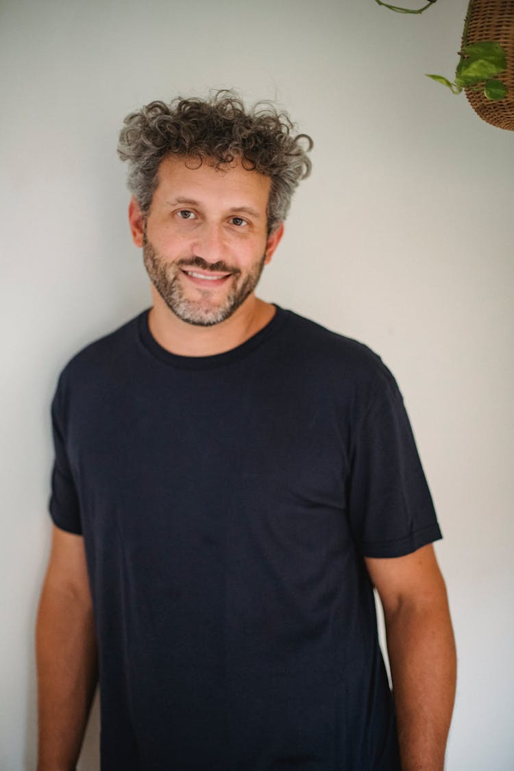 Positive Man Standing Near Wall At Home