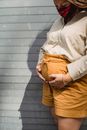 Crop pregnant woman in medical mask