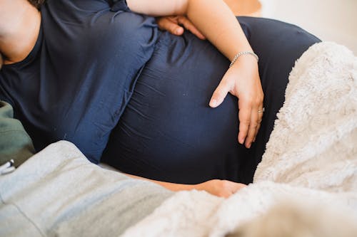 Gratis Mujer Embarazada De Cultivo Con Marido Acostado En La Cama Foto de stock
