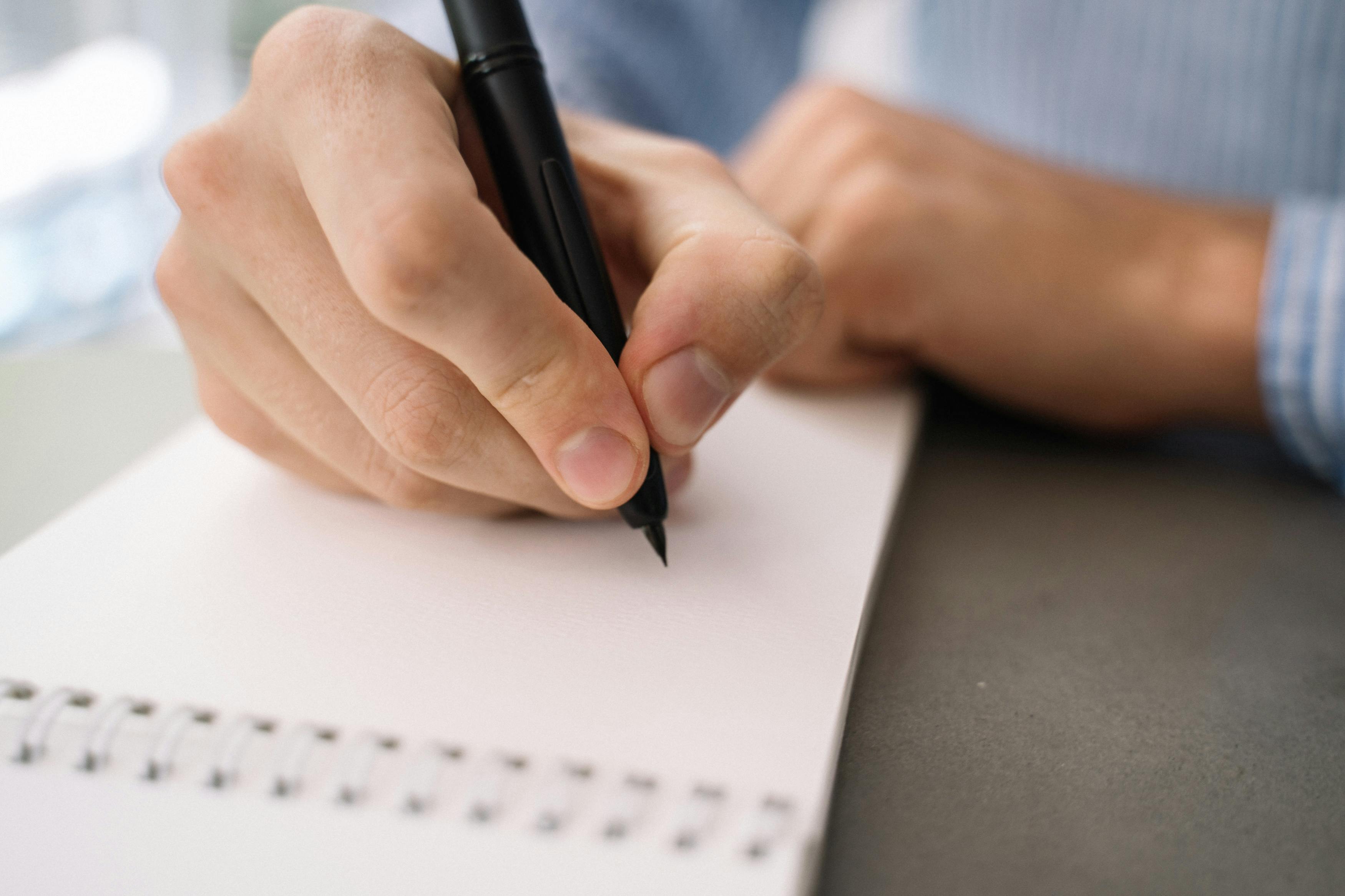 Free Close-Up Shot of a Person Writing on a Paper Stock Photo