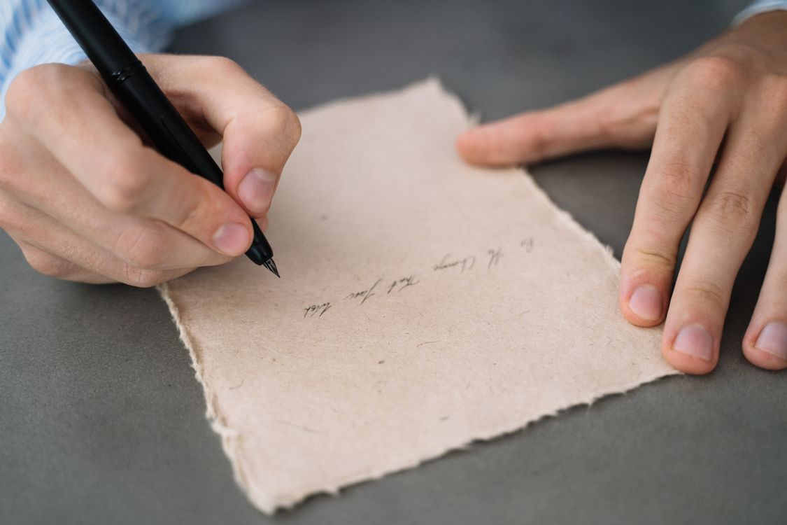 Close-Up Shot of a Person Writing on a Paper · Free Stock Photo