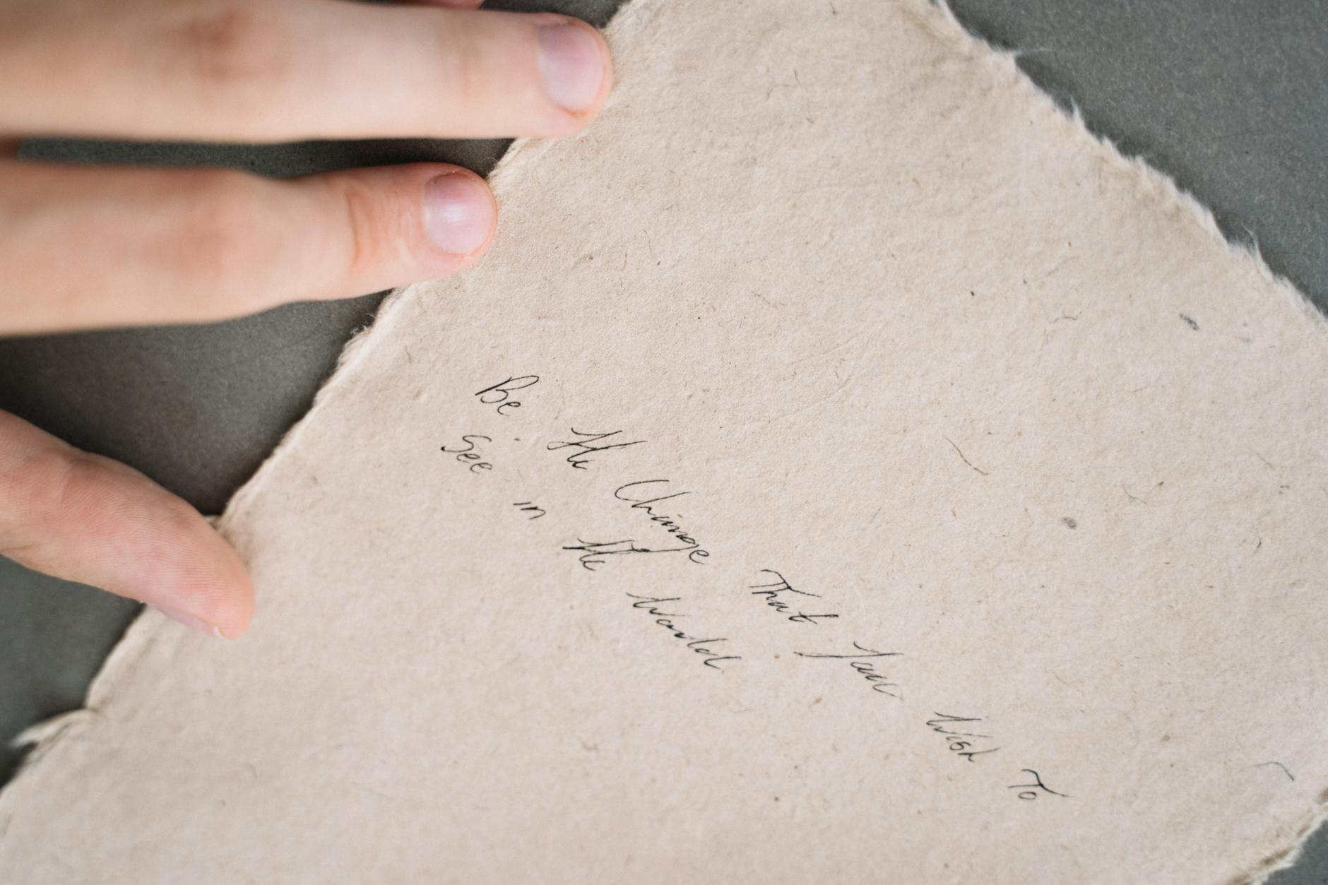 Close-up of a handwritten inspirational quote on textured paper.