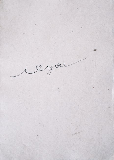 Close-up of a cursive 'I love you' handwritten on paper, conveying simplicity and affection.