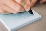 Person Writing on White Paper