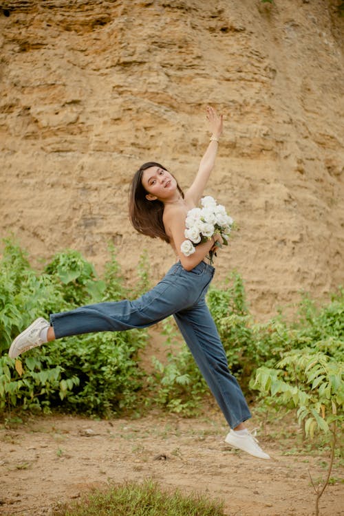 Free Cheerful woman jumping over ground Stock Photo