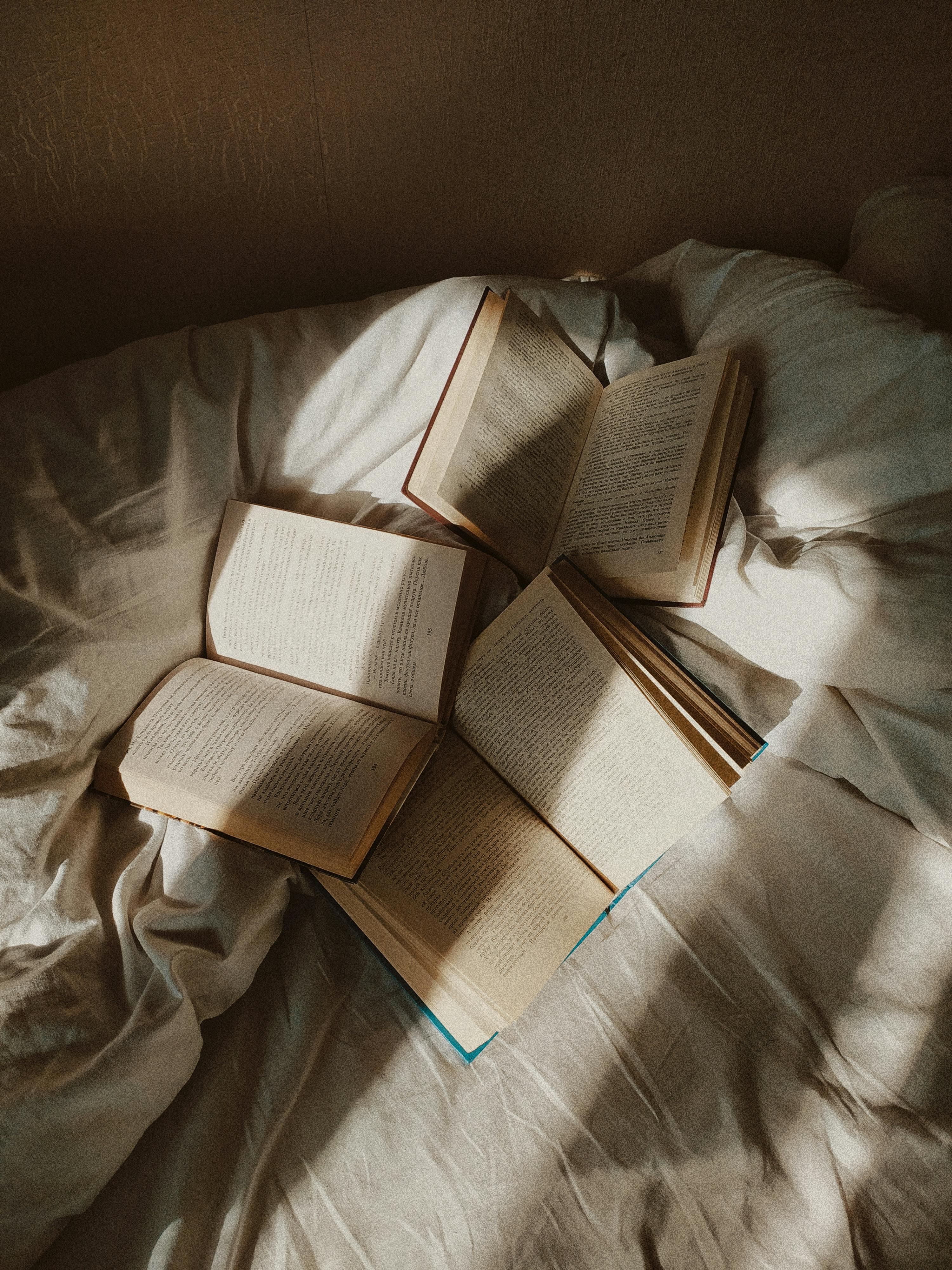 Opened books placed on disheveled bed · Free Stock Photo