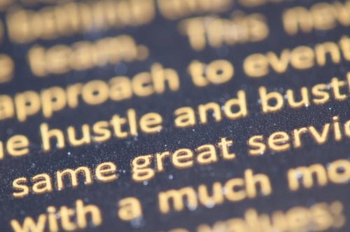 Selective Focus Photography of Hustle and Bust Text