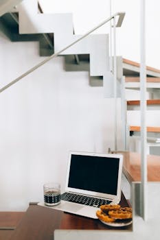 楼梯旁是时尚简约的工作区，配有笔记本电脑和小吃