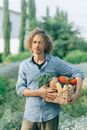 Woman in Gray and Black Long Sleeve Shirt Holding Brown Basket With Fruits
