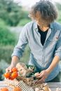 Woman in Teal Cardigan Holding Vegetable